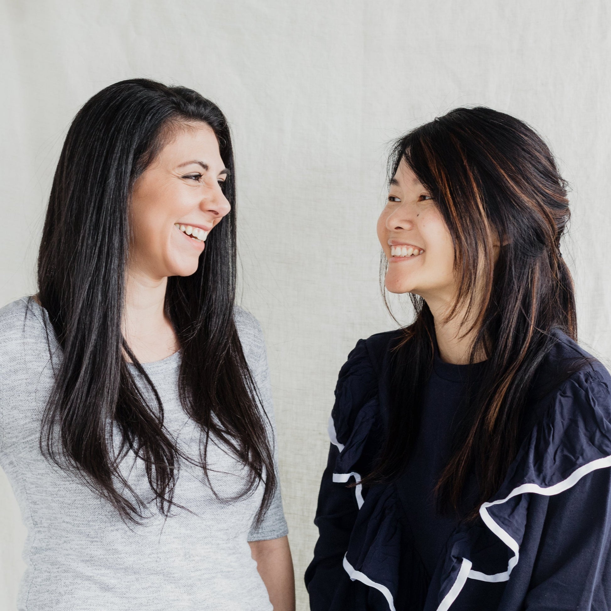 Two women smiling after a satisfying duo deal hair cut from Eminay Hair.